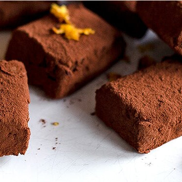 Schokoladenkonfekt mit Miss Grey und einer halben Orange daneben