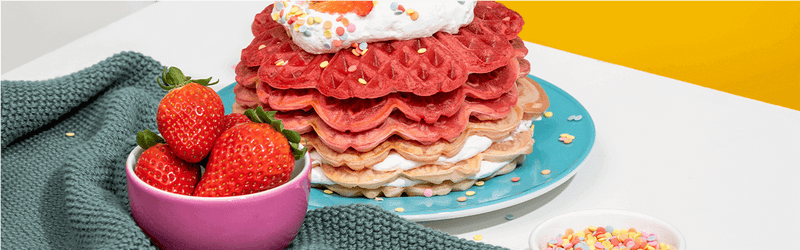 Waffeltorte auf einem Teller mit Erdbeeren daneben