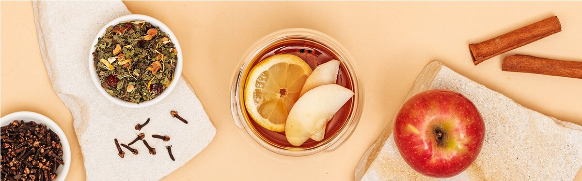 Apfel Kräuter Punsch mit Apfel, Zimstangen und Tee daneben