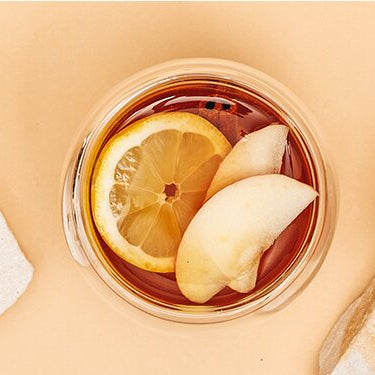 Apfel Kräuter Punsch mit Apfel, Zimstangen und Tee daneben