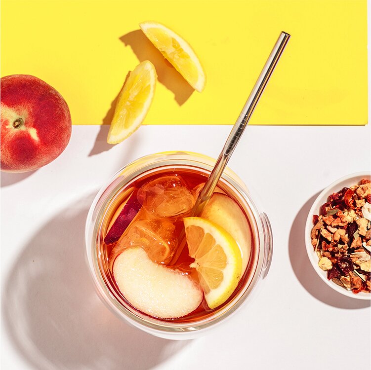 Peach Party mit Pfirsichscheiben und Zitronenscheiben im Glas und Tee daneben