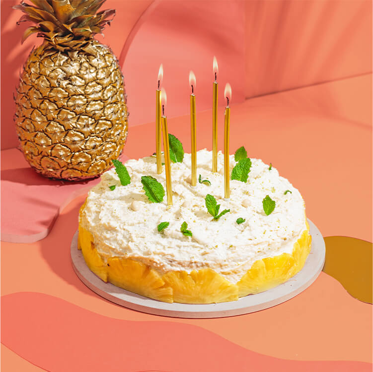 Piña Colada Torte mit einer Ananas dahinter