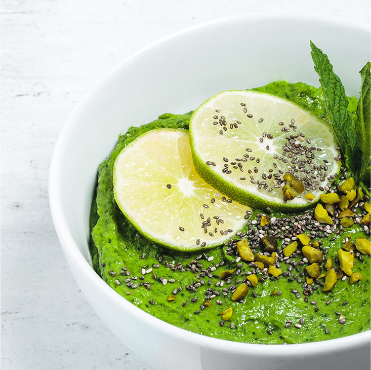 Green Power Bowl mit Limettenscheiben, Pistazien, Chia Samen als Topping
