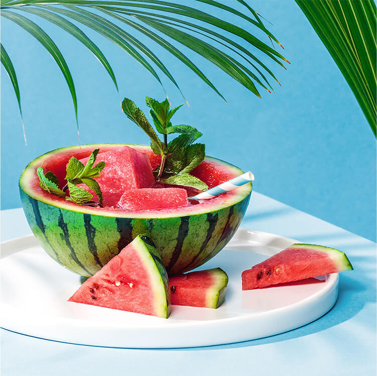 Eine halbe Wassermelone mit Roi Melon und Strohhalm